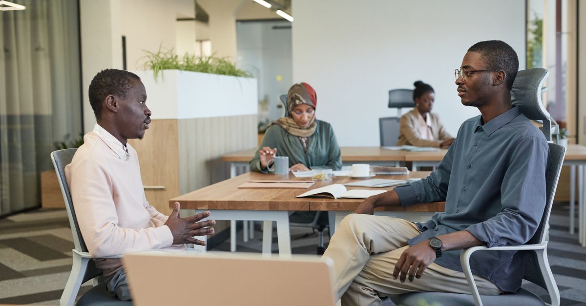 A diverse group of university staff colleagues sitting together in a meeting room