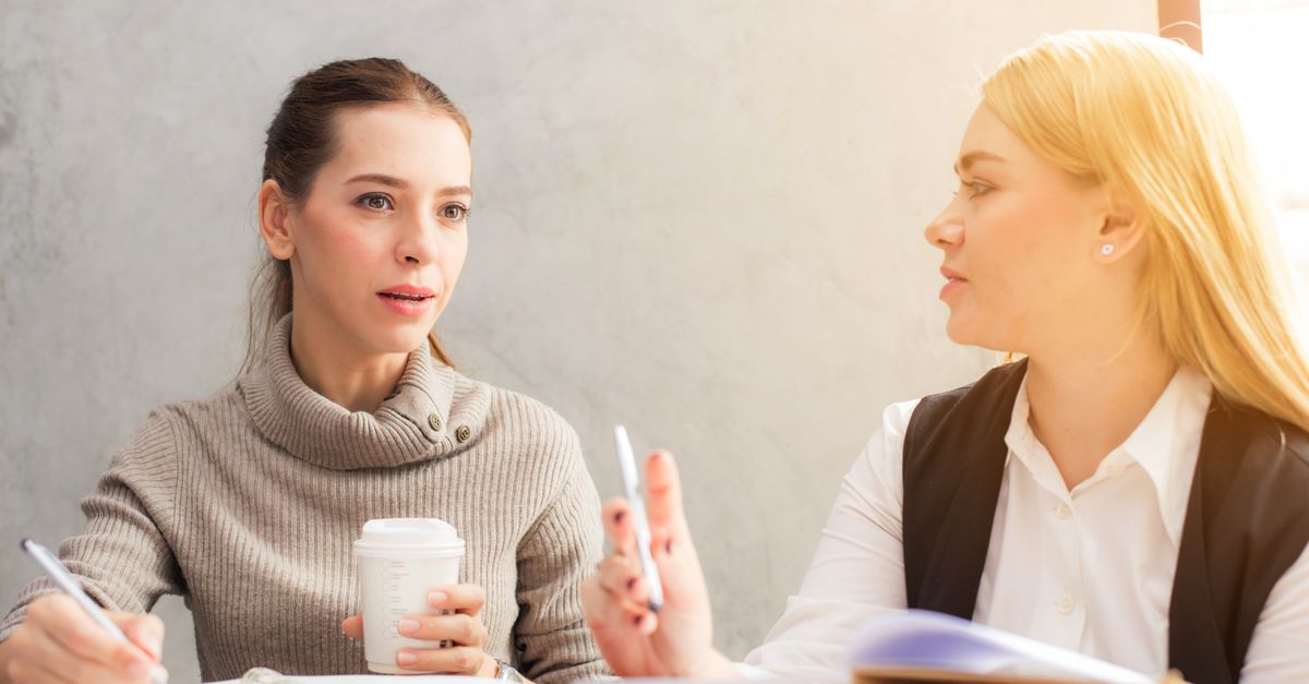 Two university colleagues having an informal conversation in an office